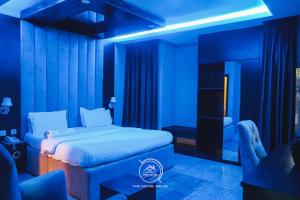 a blue room with a bed and a chair at THE HOUSE ABUJA in Abuja
