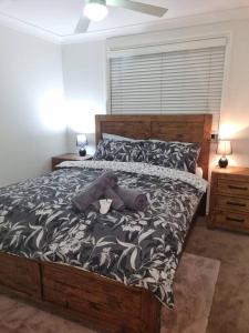 - un ours en peluche posé sur un lit dans une chambre dans l'établissement Sunrise Retreat, à Tamworth