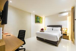 um quarto com uma cama, uma secretária e um computador em KESATRIYAN JOGJA GUEST HOUSE em Yogyakarta