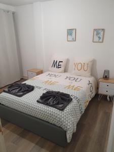 a bedroom with a bed with two black shirts on it at Beau T2 en centre ville avec place de parking auto vélo in Blois
