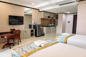 a hotel room with two beds and a kitchen at VANHSENG BOUTIQUE VIENTIANE HOTEL in Vientiane