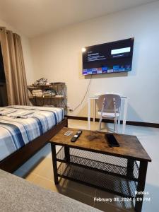 Lapu Lapu CityにあるCondo Mactanのベッド、テーブル、テレビが備わる客室です。