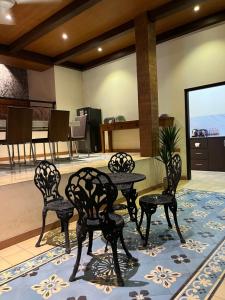 a table and four chairs on a rug in a room at Attanaya Malioboro Suites Yogyakarta in Sentool