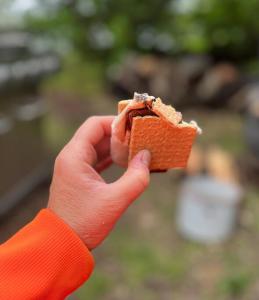 Log Cabin at Naughty Dog Private Island في Winthrop: شخص يحمل قطعة اكل في يده