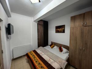 a bedroom with a bed and a cabinet and a television at Apartament Ella D25 Mackerel in Mamaia Sat/Năvodari