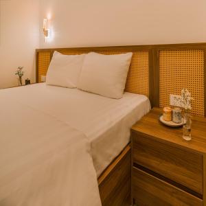 De V’Charm Hotel في Ðông Tác (1): غرفة نوم مع سرير أبيض مع خزانة خشبية