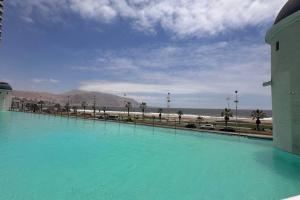 イキケにあるDepto frente a Playa con hermosa vista al mar Condominio Mar Egeoの青い海の大きなプールがビーチの横にある