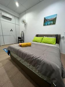 a bedroom with a large bed with green pillows at Homestay Seri Lanchang No16 in Kangar