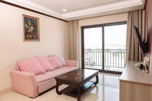 uma sala de estar com um sofá rosa e uma mesa em VANHSENG BOUTIQUE VIENTIANE HOTEL em Vientiane