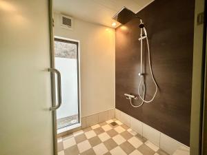 y baño con ducha y pared negra. en East Villa Shimanami Mukaishima seafront, en Onomichi