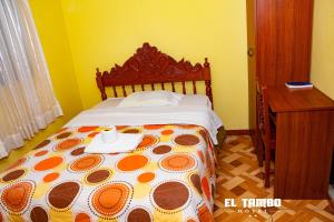 een slaapkamer met een bed met een plaat en een bureau bij HOTEL EL TAMBO in Chachapoyas