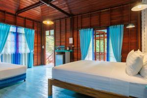 - une chambre avec 2 lits et des rideaux bleus dans l'établissement Baan Kiao, à Haad Yao 37 autres photos