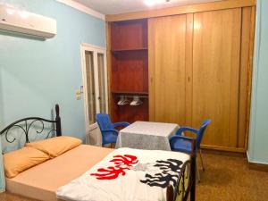 een slaapkamer met een bed en 2 stoelen en een tafel bij Men’s Retreat: Cozy Room with Free WiFi & AC in Caïro
