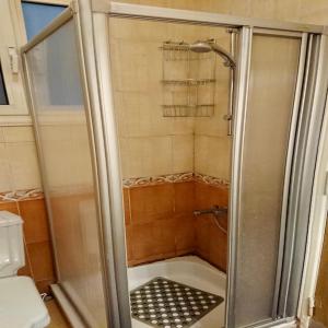 een douche met een glazen deur in de badkamer bij Men’s Retreat: Cozy Room with Free WiFi & AC in Caïro