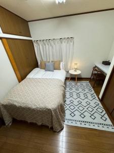 a small bedroom with a bed and a table at アンドステイ浮間3丁目 in Tokyo