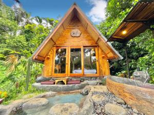 ein winziges Haus mit einem Teich davor in der Unterkunft Royal Kemala Villa - Jungle View with Private Pool in Tampaksiring