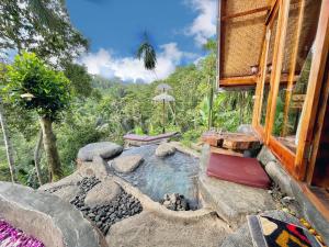 TampaksiringにあるRoyal Kemala Villa - Jungle View with Private Poolのホットタブと家のある裏庭