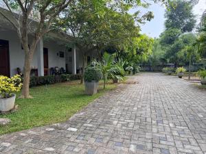 Hotel Sanhida Polonnaruwa في بولوناروا: مسار بالحصى أمام منزل به أشجار