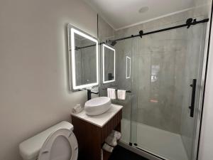 a bathroom with a shower and a toilet and a sink at Bevonshire Lodge Motel in Los Angeles