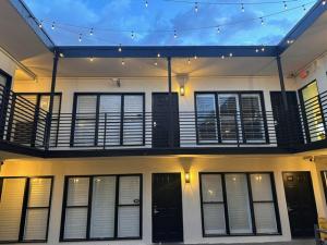 Casa con balcón con puertas y ventanas negras. en Bevonshire Lodge Motel, en Los Ángeles