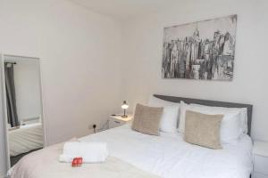 a bedroom with a white bed and a mirror at NovaNest Salford Apartment in Manchester