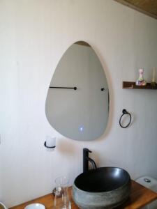 a round mirror on a wall next to a wooden table at GLAMPING Aldea Muisca in Tota