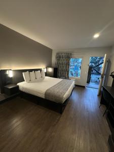 1 dormitorio con cama grande y ventana grande en Hotel del SOL, en Corona