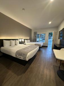 um quarto de hotel com duas camas e uma mesa em Hotel del SOL em Corona
