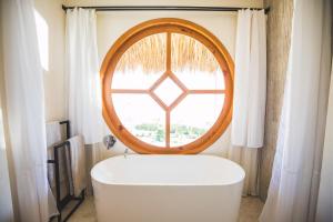 La salle de bains est pourvue d'une baignoire et d'une fenêtre. dans l'établissement Kula Maya Boutique Hotel and Spa, à San Marcos La Laguna