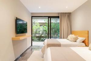 a hotel room with two beds and a television at Casa Serfin in Tulum +47 photos