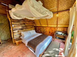 sypialnia z łóżkiem w drewnianym domku w obiekcie Royal Kemala Villa - Jungle View with Private Pool w mieście Tampaksiring