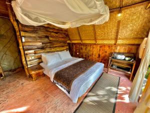 ein Schlafzimmer mit einem Bett in einem Blockhaus in der Unterkunft Royal Kemala Villa - Jungle View with Private Pool in Tampaksiring