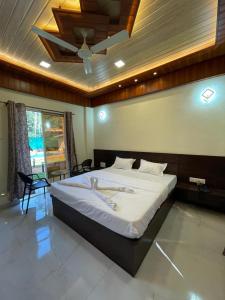 a bedroom with a large bed with a ceiling at Royal Breeze Resort in Alibag