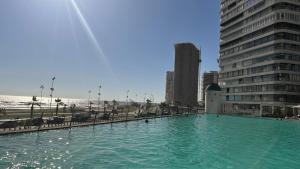 a large pool of water in front of a building at Depto frente a Playa con hermosa vista al mar Condominio Mar Egeo in Iquique