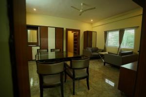 a living room with a dining room table and chairs at Sri Govindham Home Stay in Tirupati