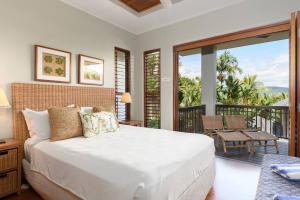 um quarto com uma cama grande e uma varanda em Far Pavilion A - Stylish Villa with Tropical Views em Port Douglas