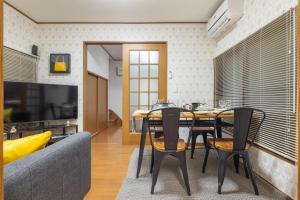 a dining room with a table and chairs and a couch at KiraKira House Elegant 3BR on Yamanote Line in Tokyo