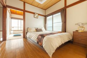 a bedroom with a large bed and windows at KiraKira House Elegant 3BR on Yamanote Line in Tokyo