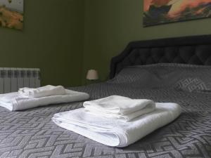 two white towels sitting on top of a bed at Bereket villa and aparts in Gabala