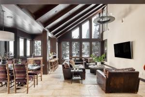 a living room with leather furniture and large windows at Bronson by AvantStay Luxurious Home On The Slopes in Olympic Valley