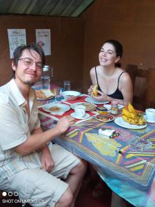 a man and woman sitting at a table with food at Vihanga Guest House in Habarana