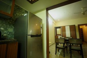a kitchen and dining room with a table and chairs at Sri Govindham Home Stay in Tirupati +34 photos