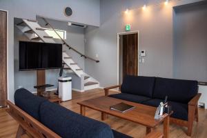 ein Wohnzimmer mit einem Sofa und einem TV in der Unterkunft Retreat Villa Aym - Vacation STAY 18153v in Minamiboso