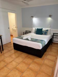 a bedroom with a large bed in a room at Cardwell Beachfront Motel in Cardwell
