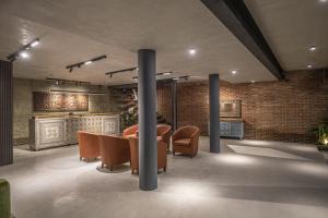 a lobby with a table and chairs and a brick wall at Ella Heritage in Ella