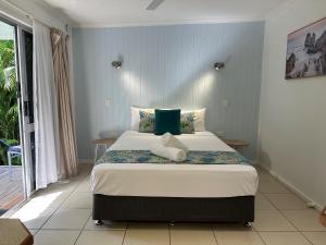 a bedroom with a large bed in a room at Cardwell Beachfront Motel in Cardwell