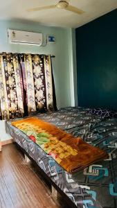 Un dormitorio con una cama con una manta de colores. en ARNAV VILLA Farmhouse & Resort, en Vajapūr