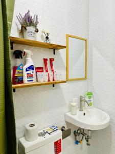 y baño con lavabo, aseo y espejo. en La Maison - Homestay near Clark Airport en Ángeles