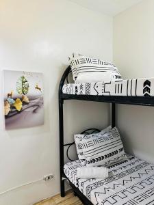 a room with three bunk beds with pillows at La Maison - Homestay near Clark Airport in Angeles