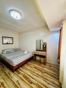 1 dormitorio con 1 cama y TV. en La Maison - Homestay near Clark Airport en Ángeles